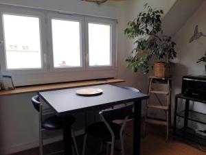 a table and chairs in a room with two windows at Superbe vue mer... Au calme in Ault