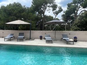 un grupo de sillas y sombrillas junto a una piscina en Villa Salteria 3, pool, private territory, pinery, en Rovinj