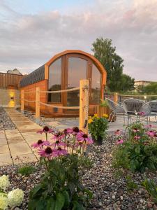 a circular building with a window and some flowers at Zatoka Marina IV in Mechelinki