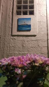a window with a picture of the ocean and purple flowers at B & B Villa Matisse in Laureana Cilento