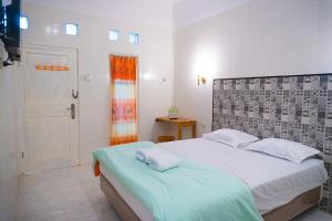 sypialnia z dużym łóżkiem i drzwiami w obiekcie Jo&Jo Hostel w mieście Bandar Lampung