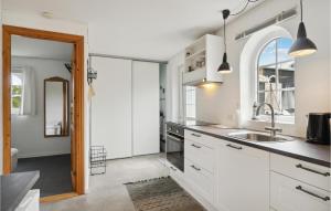 eine Küche mit weißen Schränken und einem Waschbecken in der Unterkunft 1 Bedroom Nice Home In Hadsund in Hadsund