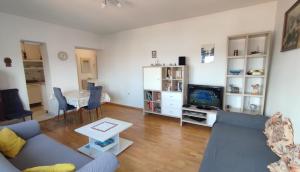 ein Wohnzimmer mit einem Sofa, einem TV und einem Tisch in der Unterkunft Apartment Marina in Zadar