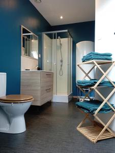 Łazienka z niebieskimi ścianami, toaletą i prysznicem w obiekcie L'essentiel w mieście Guemps