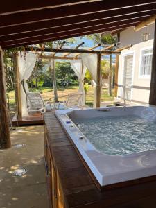 a jacuzzi tub in a yard with chairs at Cantinho do Paraíso in Socorro