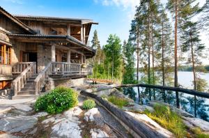a log home with a bridge leading to the front of it at Koivulahden Rapukartano in Mänttä