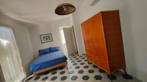 a bedroom with a bed and a wooden cabinet at La Grigua blu in Riomaggiore