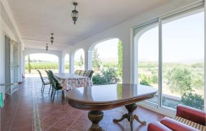 een kamer met een tafel, stoelen en ramen bij Pet Friendly Home In Murcia With Swimming Pool in Murcia