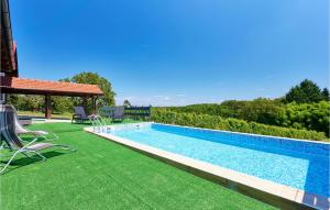 a swimming pool on a green lawn next to a house at Beautiful Home In Beslinec With Outdoor Swimming Pool 