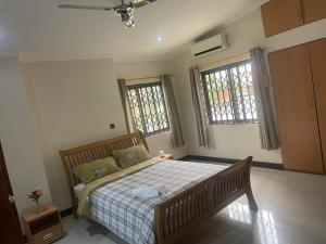 Un dormitorio con una cama y dos ventanas. en AVIEL HOME, en Accra 18 fotos más