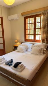 a bedroom with a large white bed with towels on it at Holiday apartment near the sea in Melission