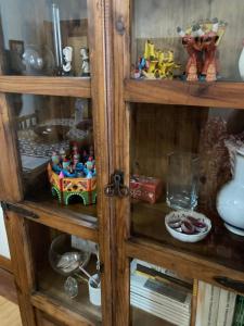 a wooden book shelf with toys on it at Tia Rita House in Figueira da Foz