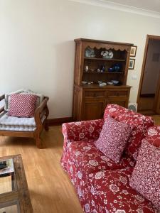 a living room with a red couch and a chair at Tia Rita House in Figueira da Foz