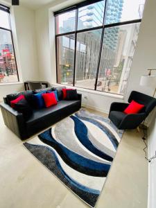 a living room with a black couch and a rug at Cozy Apt Across From Ballpark Busch Stadium in Saint Louis