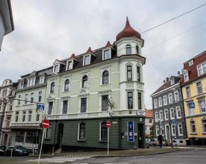 ein großes, grünes Gebäude mit einem Turm auf einer Straße in der Unterkunft Loft mit Billard-Tisch und PS4 in Wuppertal