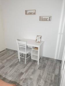 einen weißen Schreibtisch mit Stuhl in einem Zimmer in der Unterkunft La Terracotta Rer C -N104-A6 in Brétigny-sur-Orge