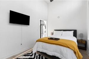 a bedroom with a bed and a flat screen tv at Cozy Apt Across From Ballpark Busch Stadium in Saint Louis