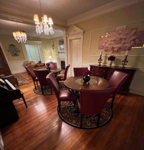 sala de estar con mesa, sillas y sofá en Opus House Historic Natchitoches en Natchitoches