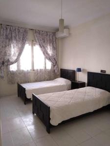 a bedroom with two beds and a window at Bel appartement plein centre avec double terrasse in Oujda