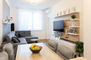 ein Wohnzimmer mit einem Sofa und einem Tisch mit einer Obstschale in der Unterkunft Lux oasis with private parking in Zagreb