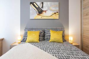 Un dormitorio con una cama con dos almohadas amarillas. en Lux oasis with private parking, en Zagreb