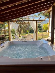 a jacuzzi tub in a yard with chairs at Cantinho do Paraíso in Socorro