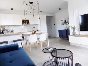 a living room and kitchen with a blue couch and chairs at Penthouse Aurelia, rooftop terrace & jacuzzi in Turanj