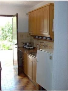 cocina con armarios de madera y nevera blanca en Argo House '6, en Korfos