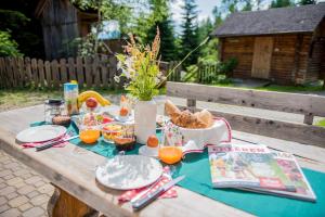 a picnic table with food and orange juice on it at Katschwaldhütte in Sankt Wolfgang