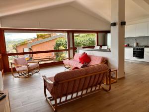 a living room with two chairs and a large window at Tuscan Sunrise in Porto Santo Stefano