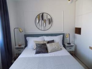 1 dormitorio con 1 cama blanca grande con almohadas en Penthouse Aurelia, rooftop terrace & jacuzzi, en Turanj