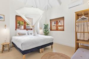 a bedroom with a bed with a canopy at Villa Blou, steps from the Jan Thiel Beach in Jan Thiel