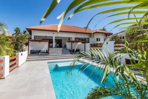a villa with a swimming pool and a house at Villa Blou, steps from the Jan Thiel Beach in Jan Thiel