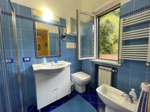 ein Badezimmer mit einem Waschbecken, einem WC und einem Spiegel in der Unterkunft Camera con ingresso indipendente in Ogliastro Cilento