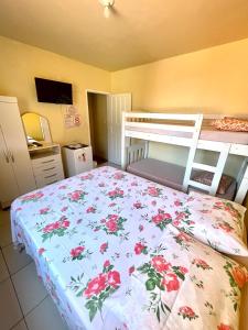 a bedroom with a bed with a floral bedspread at Pousada Sabrinna in Maceió