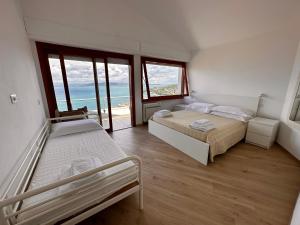 um quarto com 2 camas e vista para o oceano em Tuscan Sunrise em Porto Santo Stefano