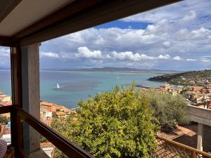 a view of a sailboat in the water from a balcony at Tuscan Sunrise in Porto Santo Stefano