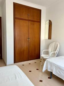 a bedroom with a closet and a chair and a bed at Casa CaboMar in Torrevieja