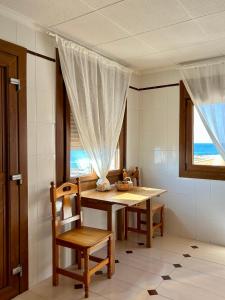 托雷維耶哈的住宿－Casa CaboMar，一间带桌椅和窗户的用餐室