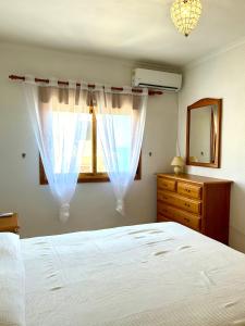 1 dormitorio con 1 cama blanca, vestidor y ventana en Casa CaboMar, en Torrevieja