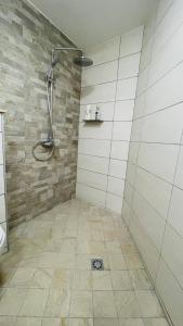 Łazienka z prysznicem i podłogą wyłożoną kafelkami w obiekcie Auae hills lodge w mieście Faaa