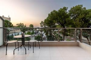 een balkon met een tafel en stoelen en uitzicht bij Byron Luxury Apartments in Aigio