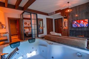 uma banheira num quarto com uma televisão em Hayal Vadisi Suite Hotel em Trabzon