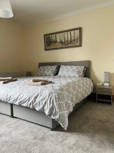1 dormitorio con 1 cama con una foto en la pared en Epworth Cottage, en Crich