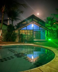 a house with a swimming pool at night at Pousada Refúgio do Manatí in Canoa Quebrada