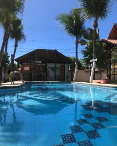 una gran piscina con palmeras en el fondo en Pousada Refúgio do Manatí, en Canoa Quebrada