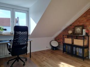 an office with a desk and a chair in a attic at Old Town Apartment with Netflix and AC in Kaunas
