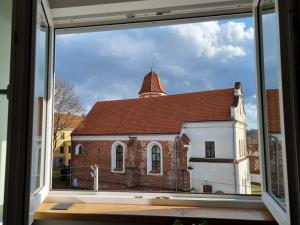 a window view of a church with a roof at Old Town Apartment with Netflix and AC in Kaunas