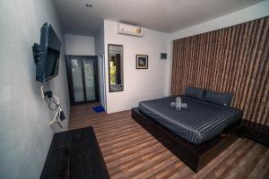 1 dormitorio con 1 cama y TV de pantalla plana en Green Mango en Thongsala
