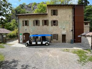 einem Golfwagen, der vor einem Gebäude parkt in der Unterkunft Borgo dei Sassi di Roccamalatina - Room and Breakfast in Rocca Malatina